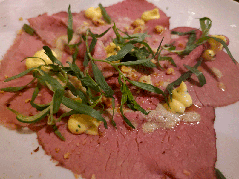 Carpaccio di Marchigiana alla brace, salsa bernese, dragoncello, menta e vinaigrette di foie gras e nocciola del ristorante "Il Marchese del Grillo"