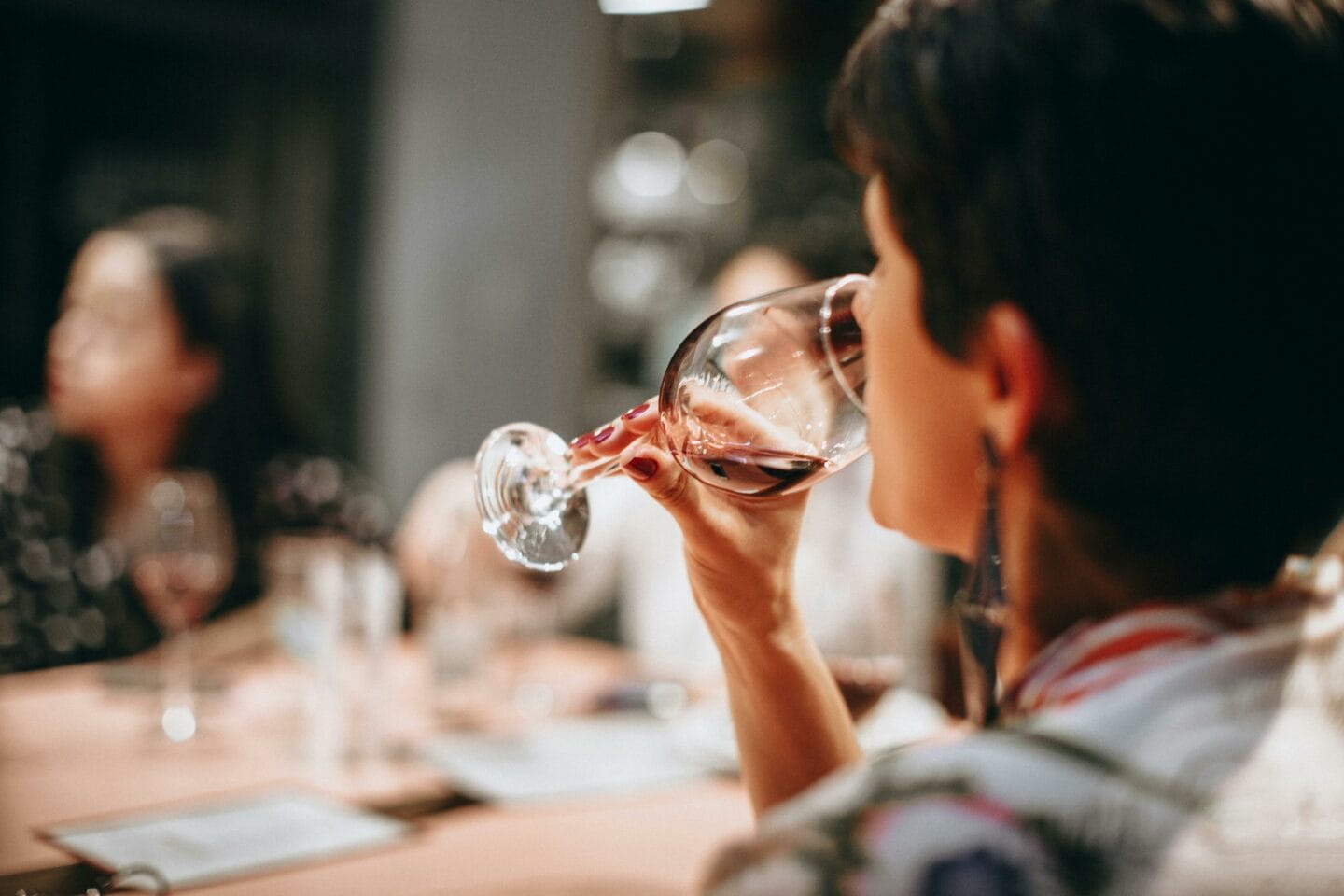 Un donna che beve del vino rosso